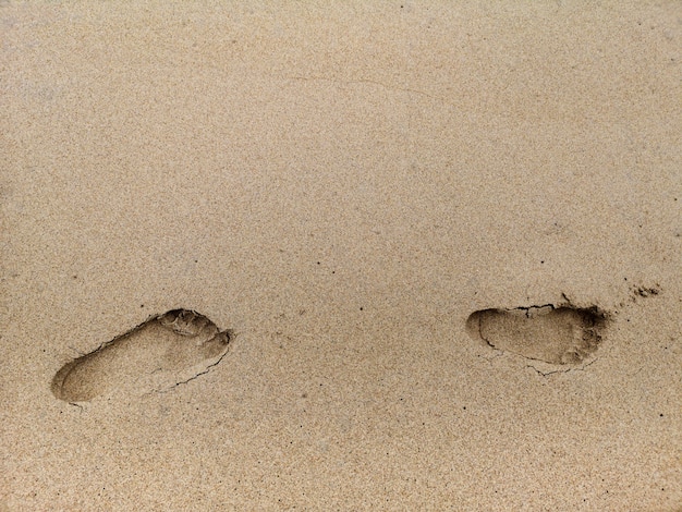 Photo footprint on the beach sand background.