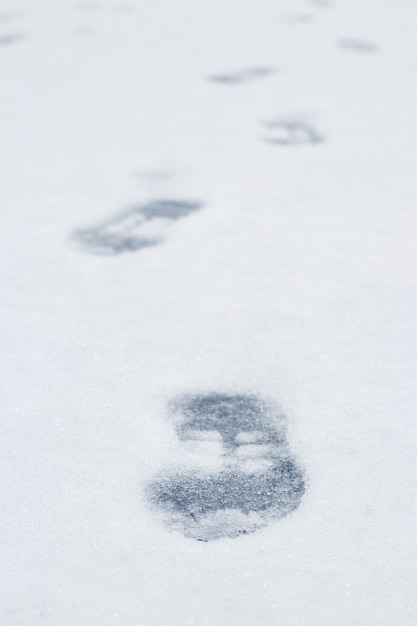 Footprints of a man on white snow in winter, winter background