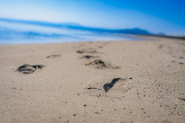 Photo footprints on sand at beach against sky