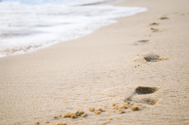 Footprints in the sand at sunset