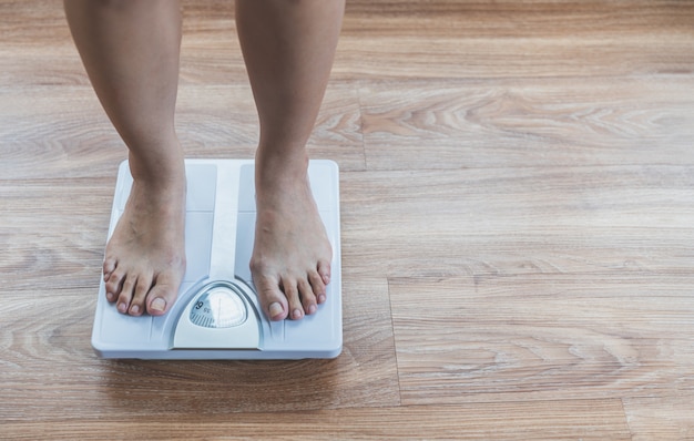 Foots of asian woman on weight scale,Lose weight concept