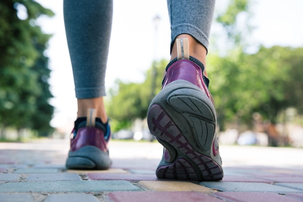 Footwear on female feet running on road