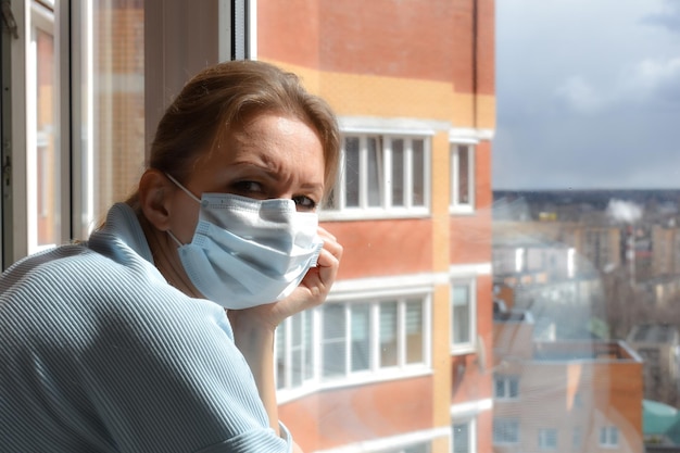 Photo forced isolation the woman in the mask looks sad woman in medical mask