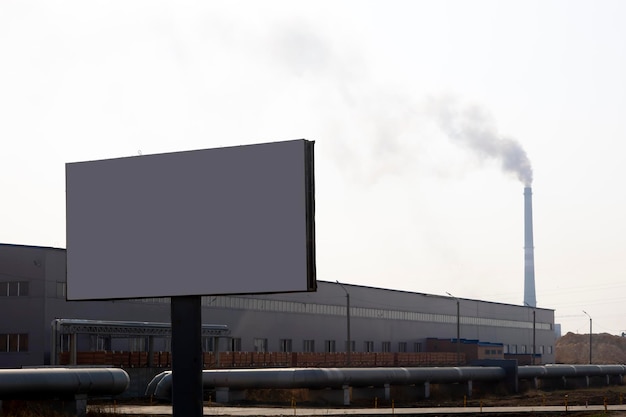 In the foreground is a banner and in the background is a factory and a chimney with smoke