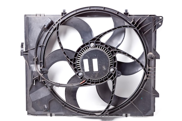 Foreground of a metal car spare part engine radiator cooling fan on a white isolated background Auto repair in the workshop