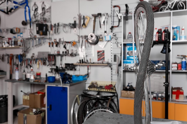 Photo in foreground on the rack in the garage workshop is a deformed bicycle wheel