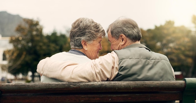 Forehead touch and senior couple in a park with love happy and conversation with romantic bonding Fun old people and elderly man embrace woman with care romance or soulmate connection outdoor