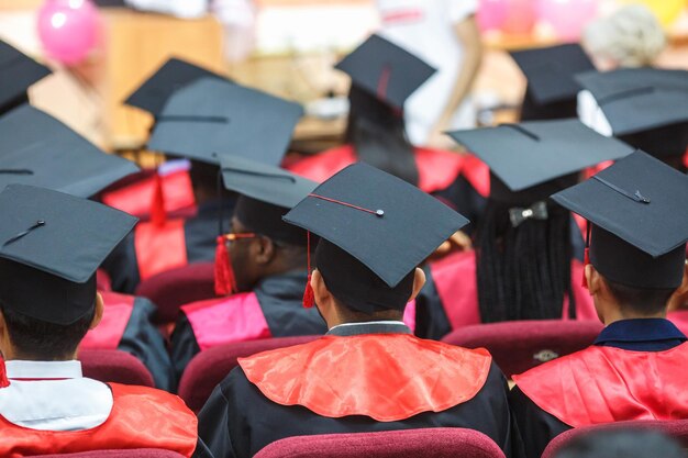 Foreign medical students in square academic graduation caps and
black raincoats during commencement