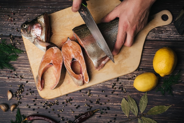 Forel op het bord, dat een man kookt met een mes op tafel