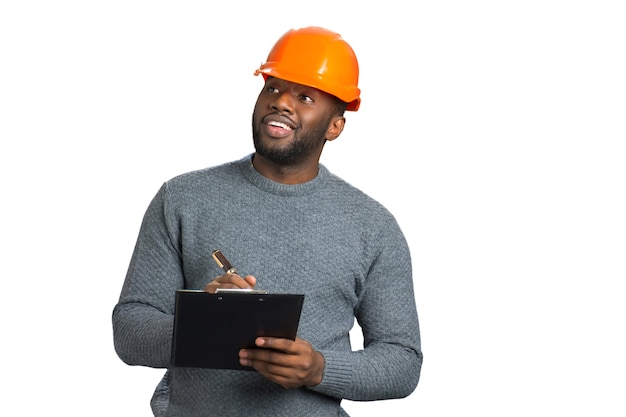 Foreman in casual wear checking object. Positive young architect looking at building and writing