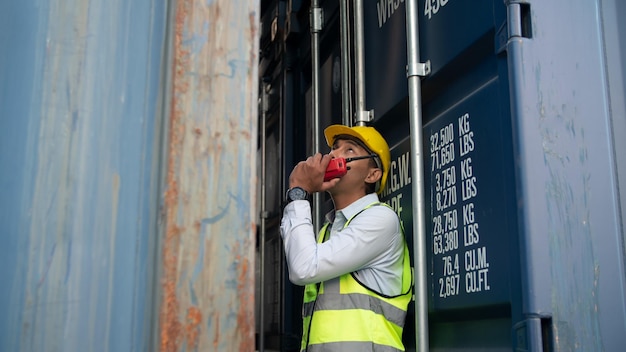 Foreman control loading Containers box from Cargo freight ship for import export. Freight containers in sea port.