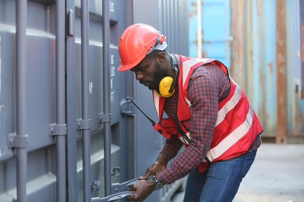 Foreman control loading containers box from cargo freight ship\
for import export. freight containers in sea port.