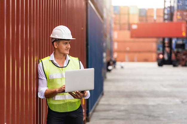 Бригадир, держащий документы, ходьба и проверка ящика контейнеров с грузового судна для экспорта и импорта