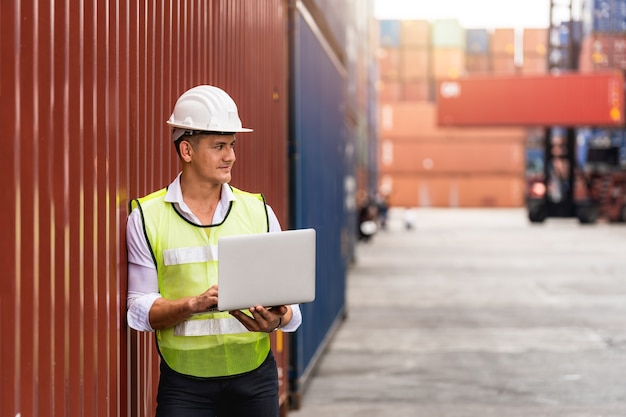 Foreman holding document, walking and checking the containers box from cargo ship for export and import