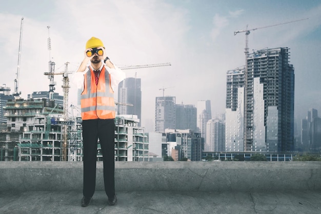 Foreman looking at the construction site with binocular