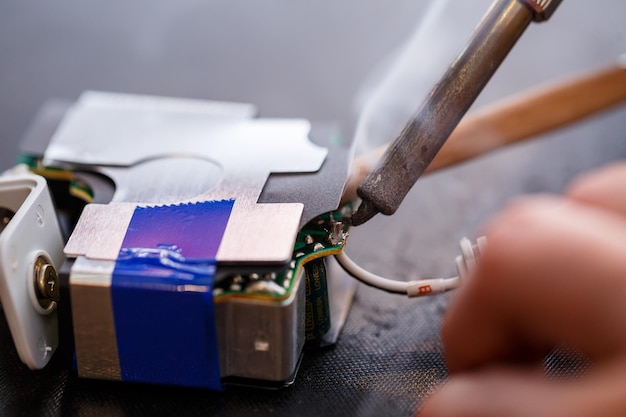 A foreman repairs an electrical appliance in his repair\
office