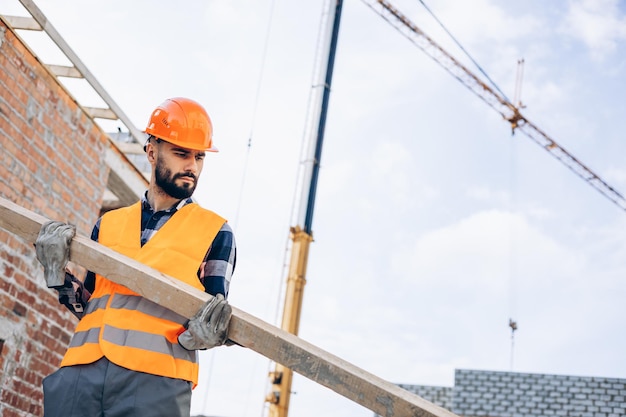 Foreman working on building object holding wooden stick