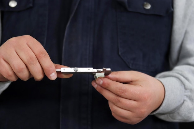 Foreman working by hand and measuring metal with caliper tool