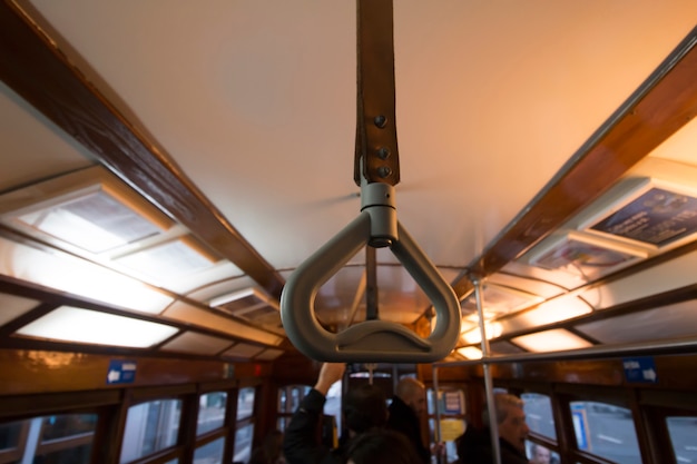 Forensenhandvat op een historische gele tram