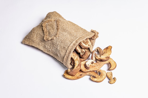 Forest dried edible mushrooms in sackcloth bag isolated