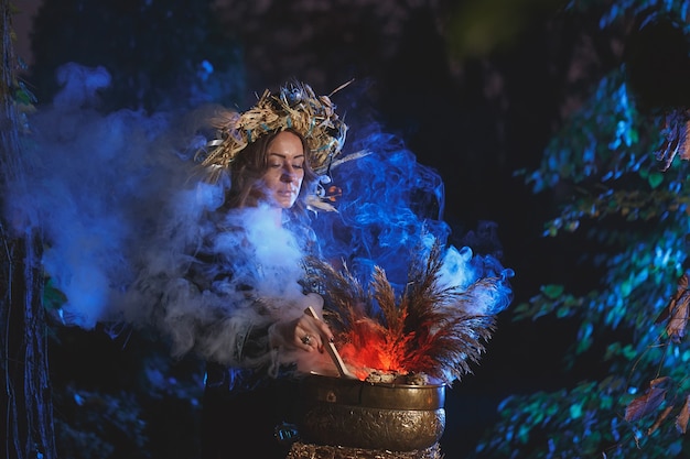 Una strega della foresta prepara una pozione con in mano una bambola voodoo