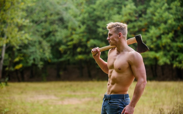 Forester with axe. Sexy macho bare torso. Surviving in wild nature. Muscular athlete in forest. Sport and fitness. Muscular body. Strength and power concept. Handsome shirtless man muscular body.