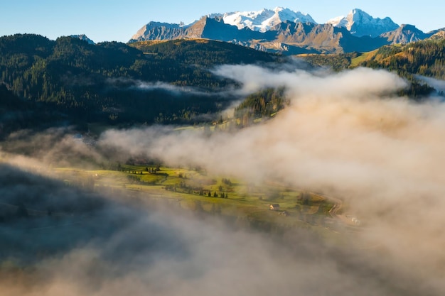 写真 森と岩石の山々 濃い霧に囲まれて 晴れた夏の朝 景色の良いアルプス山脈