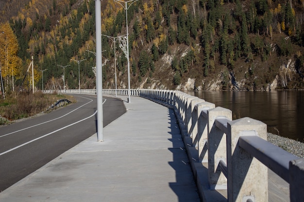 Forests cover the mountains. Walk along the embankment along the river