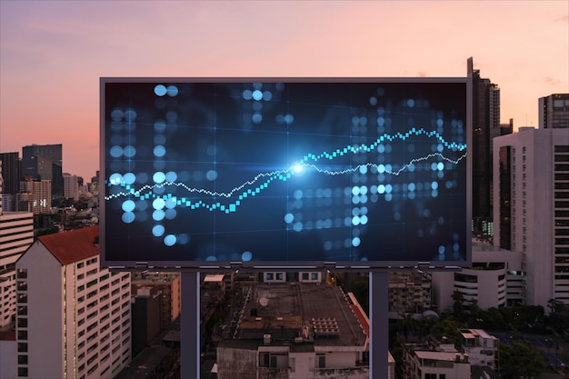 Forex graph hologram on billboard aerial night panoramic\
cityscape of bangkok the developed location for stock market\
researchers in southeast asia the concept of fundamental\
analysis