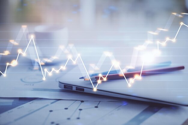 Forex graph hologram on table with computer background Double exposure Concept of financial markets