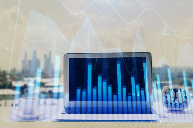 Forex graph hologram on table with computer background Multi exposure Concept of financial markets