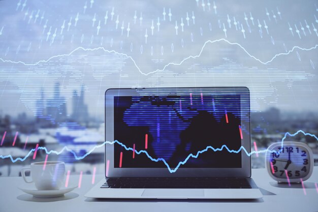 Forex graph hologram on table with computer background Multi exposure Concept of financial markets