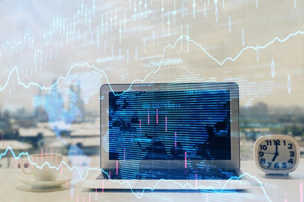 Forex graph hologram on table with computer background Multi exposure Concept of financial markets