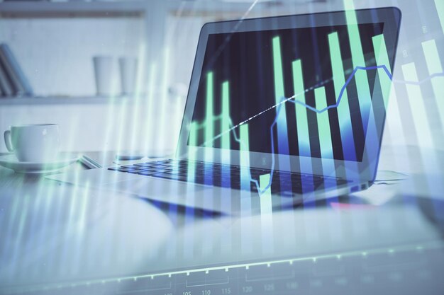 forex graph hologram on table with computer background multi exposure concept of financial markets