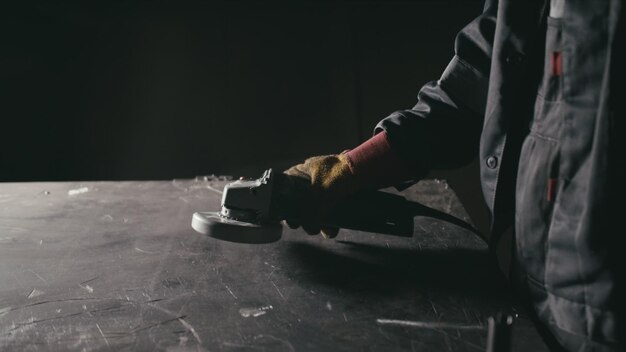 Forge workshop Smithy manual production Industrial worker using angle grinder and cutting steel