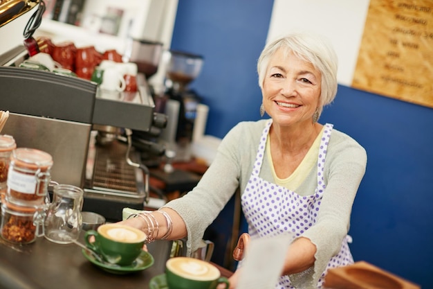 Photo forget the rest our coffees the best shot of a senior woman serving coffee in a cafe