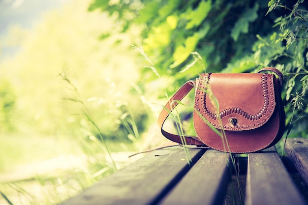 Foto borsa a mano in pelle dimenticata su una panchina del parco nessuno