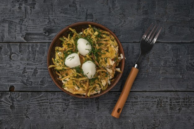 Una forchetta accanto a una ciotola di insalata di uova di quaglia su un tavolo di legno