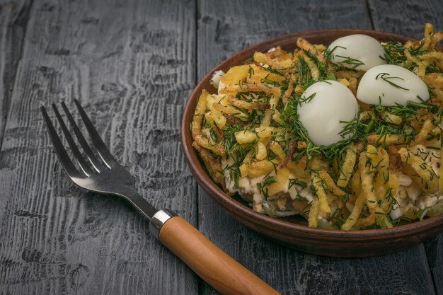 A fork next to a bowl of quail egg salad