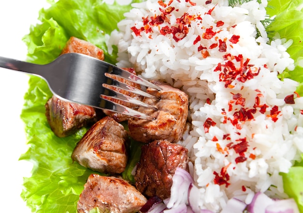 Fork on a dish with rice and meat