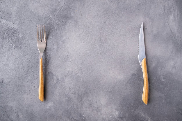 Fork and knife over gray background.. Top view