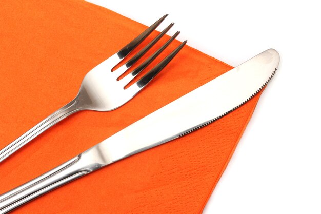 Fork and knife in a orange cloth on white