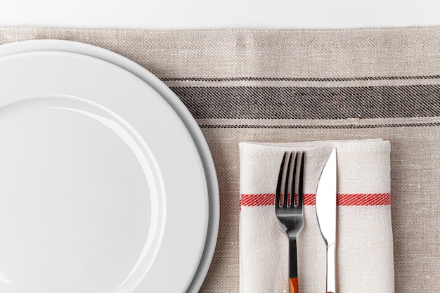 Fork, knife and plate on towel. Isolated on white background. Close up.