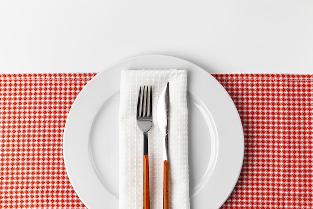 Fork, knife and plate on towel. Isolated on white background.