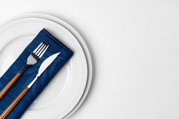 Photo fork, knife and plate on towel. isolated on white background.