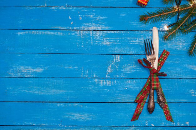 Fork and knife tied with a ribbon on a blue wooden background