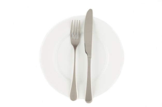 Вилка и нож на белой тарелке