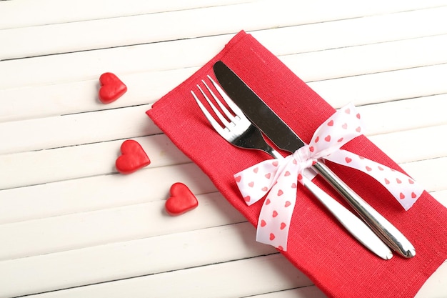 Fork and knife with decorative hearts on wooden table