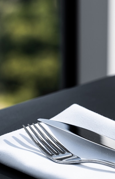 Fork and knife with white napkin on table in luxury restaurant outdoors fine dining menu for wedding...