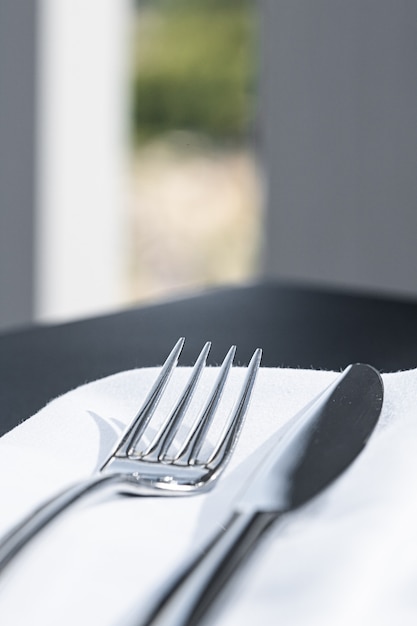 Fork and knife with white napkin on table in luxury restaurant outdoors fine dining menu for wedding...